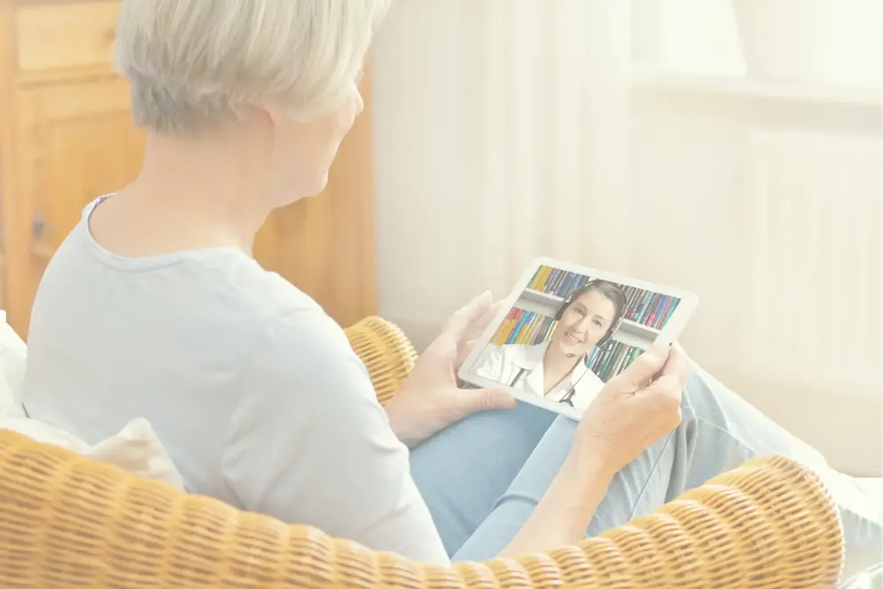 AdobeStock_289092444 telemedicine concept, woman with grey hair, with tablet pc during an online consultation with her doctor in her living room