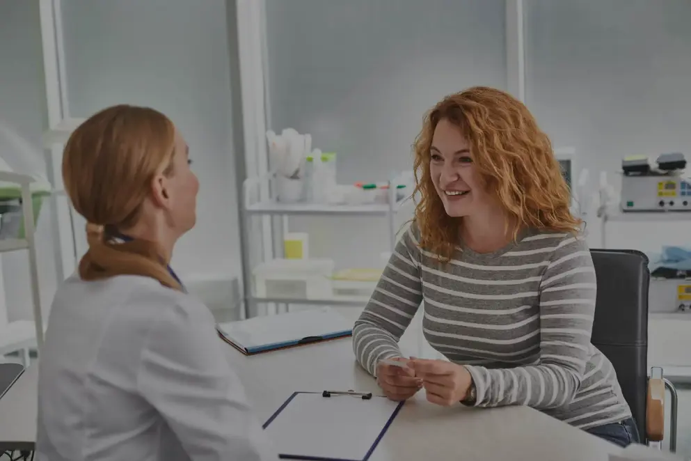 Portrait of mature lady sitting at the table and having consultation with gynecologist