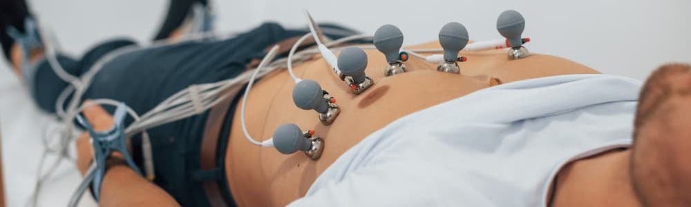 Man lying on the bed in the clinic and getting electrocardiogram test
